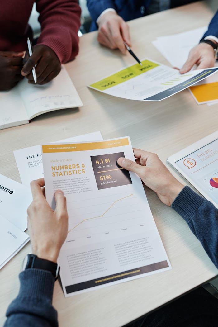 pexels-photo-7108589-1 A group reviews business statistics and reports on a wooden table.